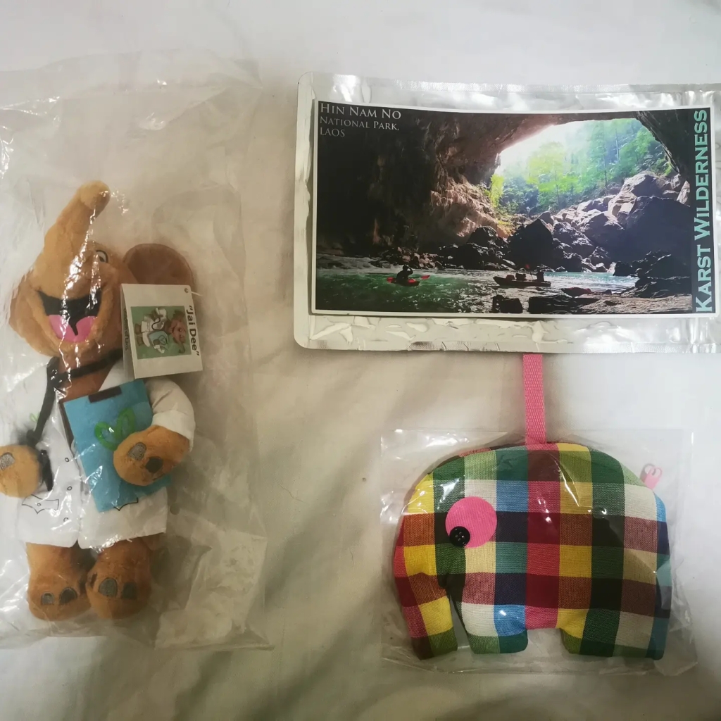 Une carte postale du Laos, un portefeuille et une mascotte éléphant